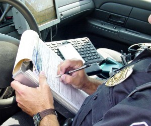 A police officer writing a report in their vehicle