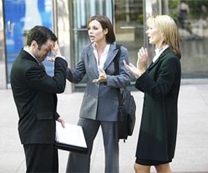 Three people arguing outside a building